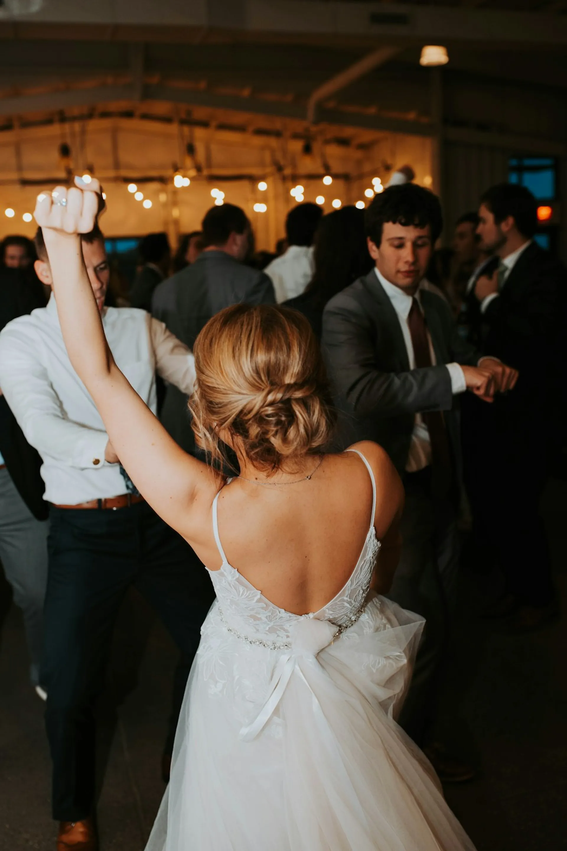 A couple slow-dancing in a warm, candlelit room