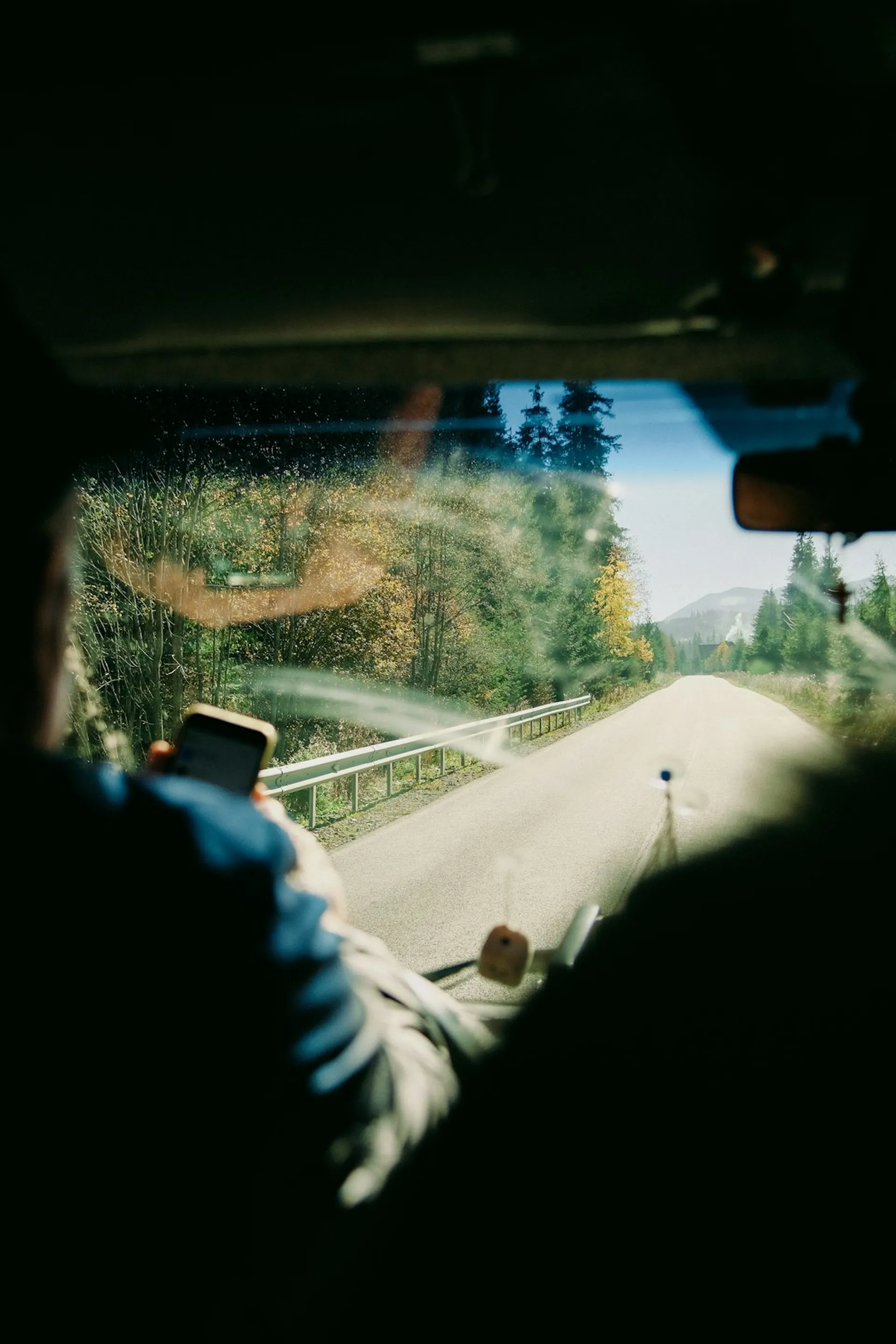 View from inside a car on a road trip through forested hills