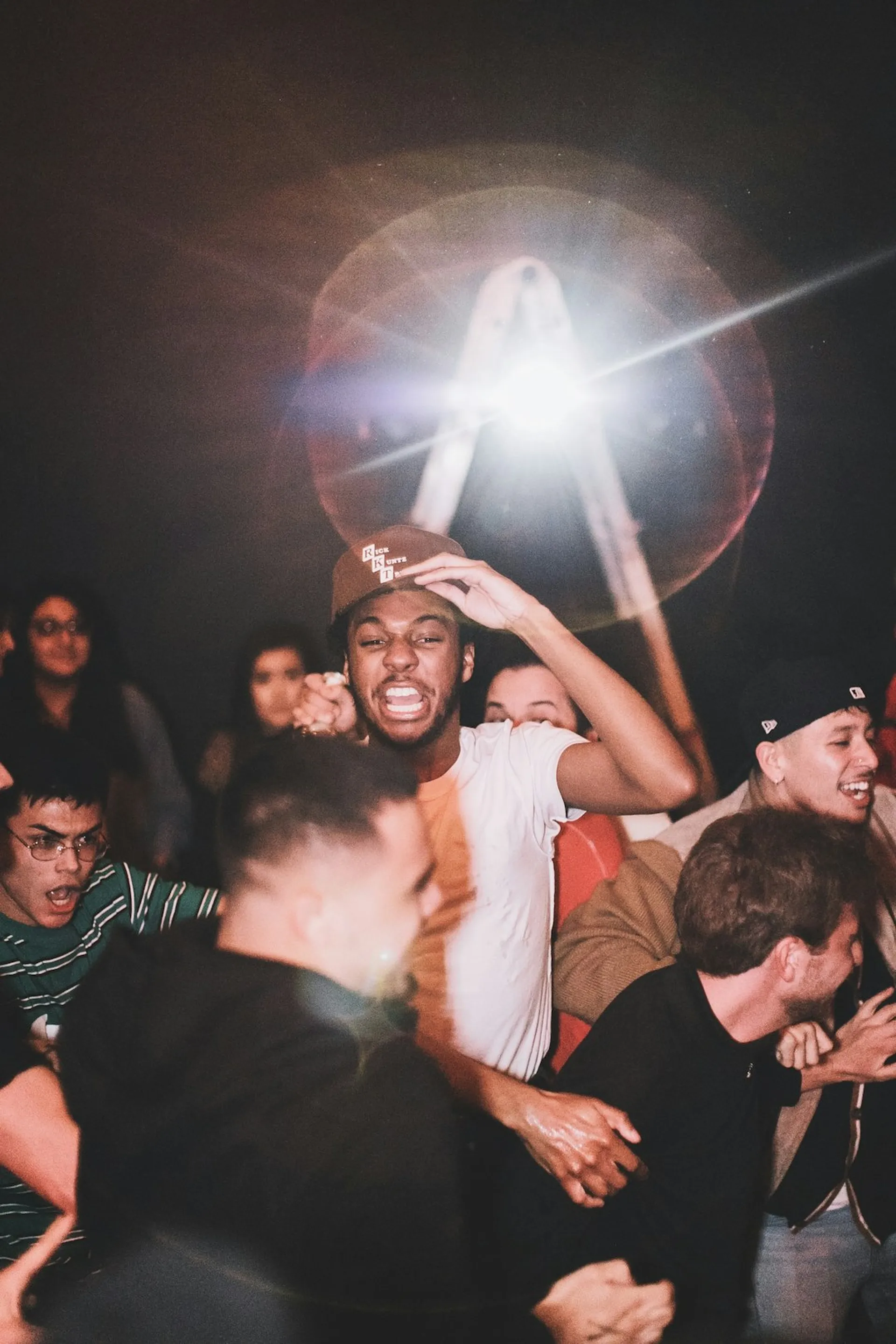 A crowd of people cheering together at a night-time event