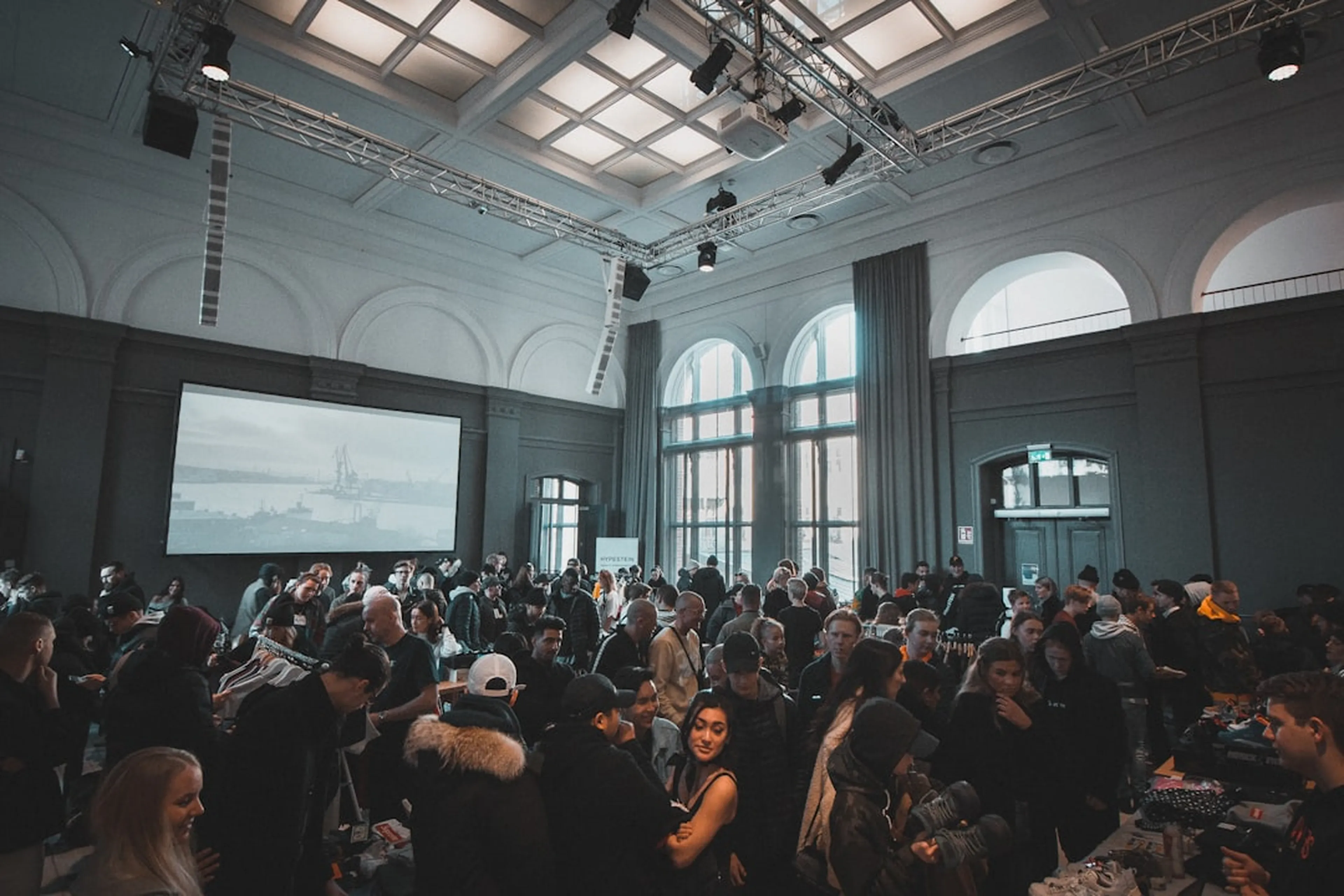 Menschen versammelt bei einem Firmenevent in einer großen Halle
