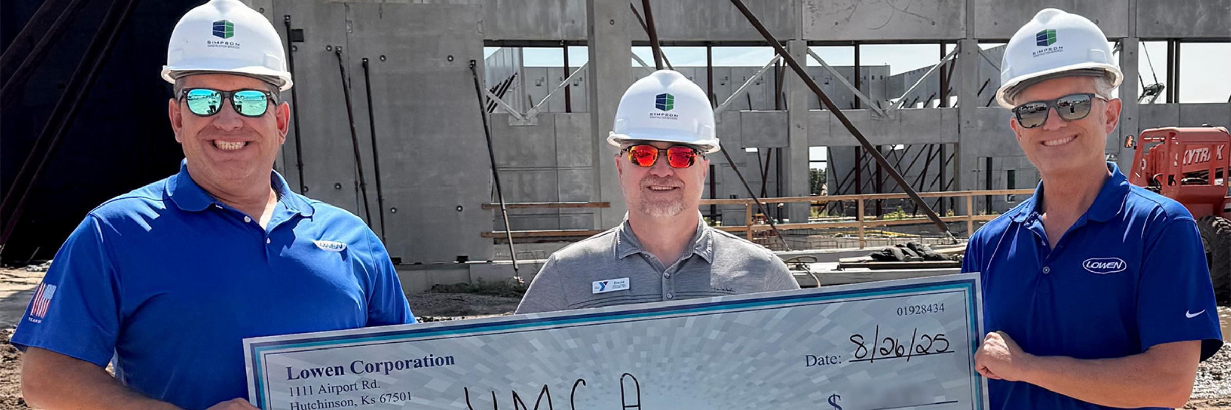 Lowen Corporation representatives present a donation check to the Hutchinson YMCA at the construction site for the new facility in Hutchinson, Kansas.