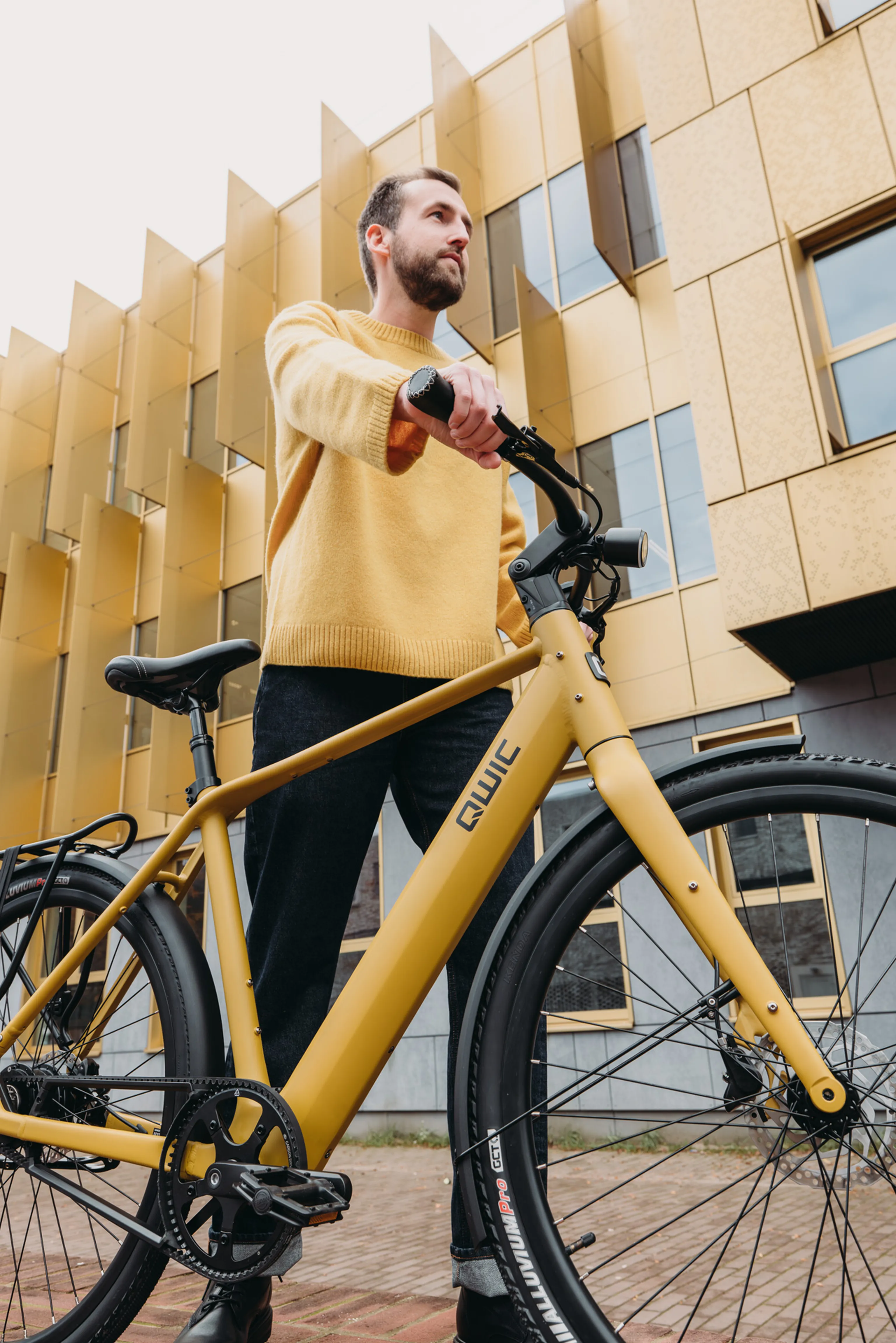 Man staat met een QWIC Signal in Oker Yellow in een stedelijke omgeving