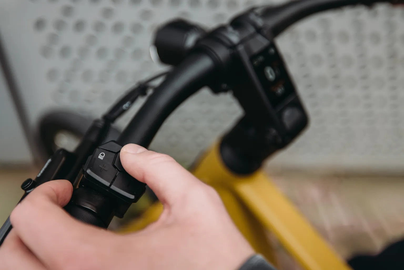 Hand bedient de knoppen op het stuur van een QWIC Signal