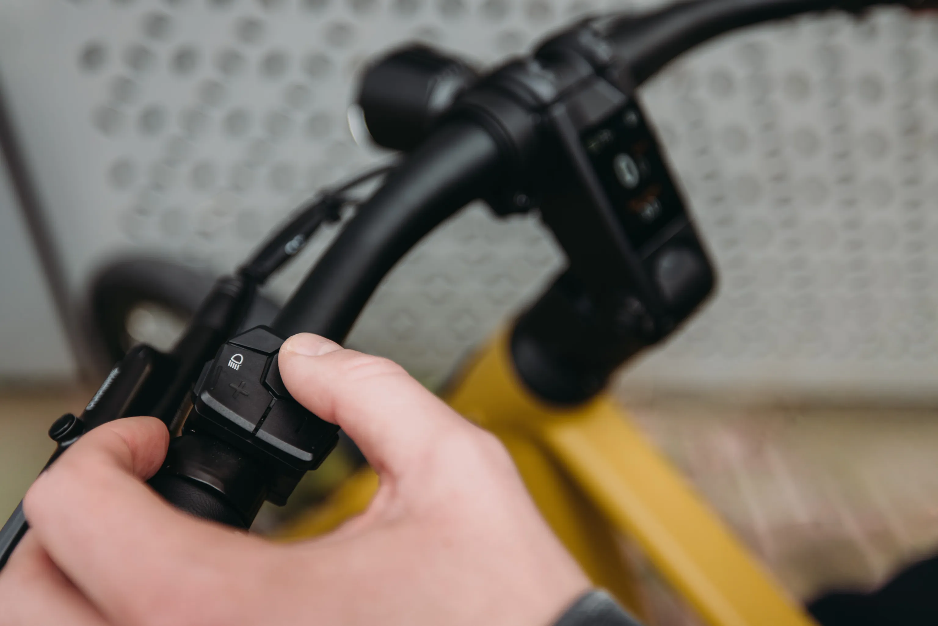 Hand bedient de knoppen op het stuur van een QWIC Signal