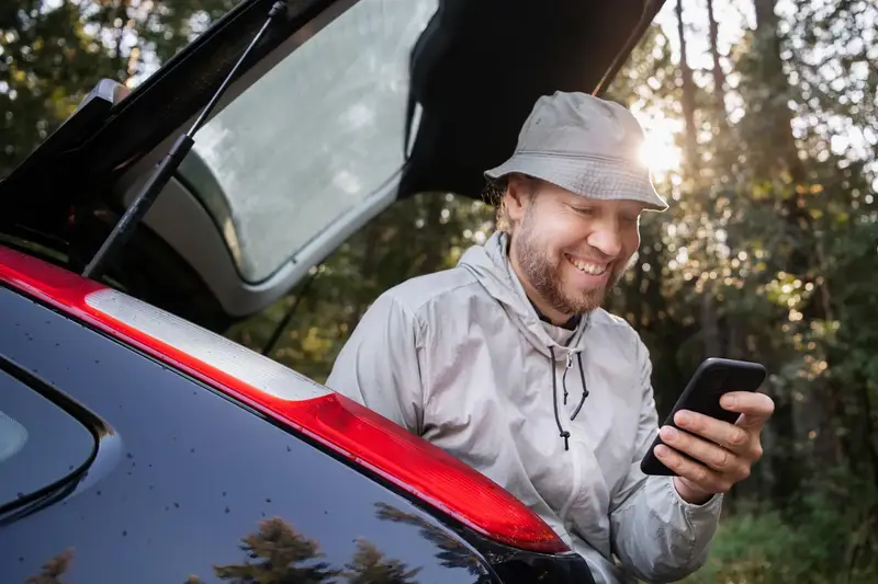 smiling man sitting on the boot lid