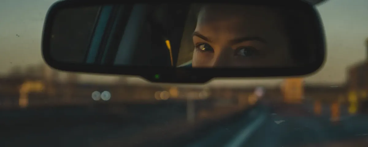 Woman looking in the rear-view mirror