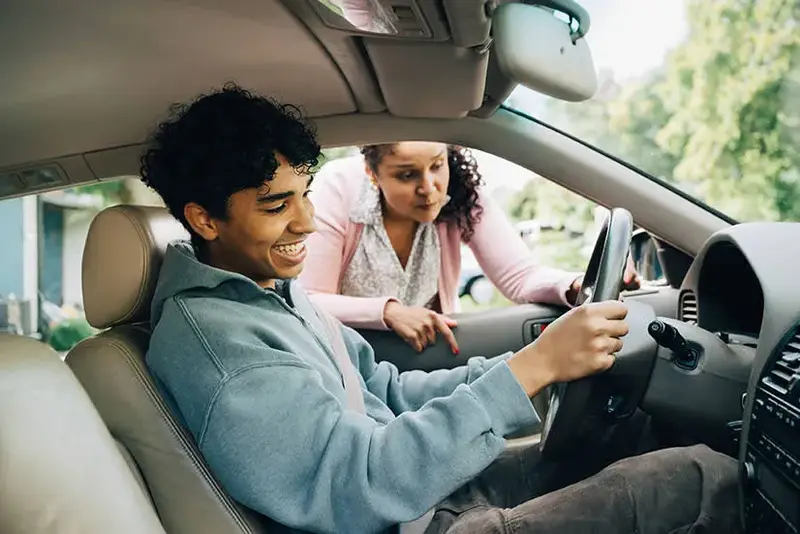 Man inside car, woman outside, smiling