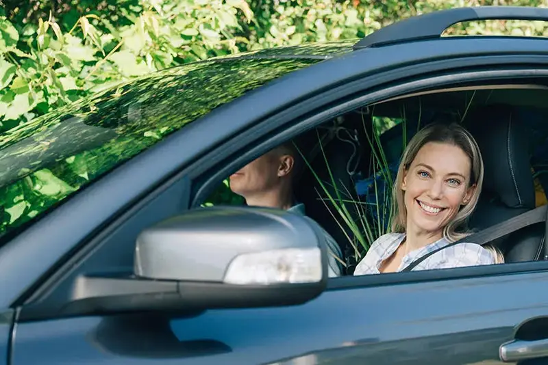 Couple on car, woman drive and smile