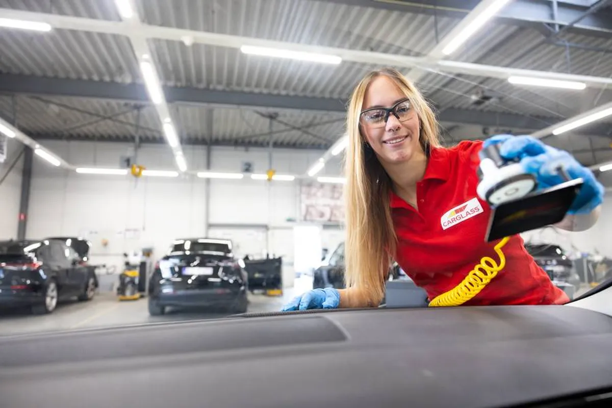 Välkomstbild på en kvinna på Carglass verkstad som lagar en vindruta
