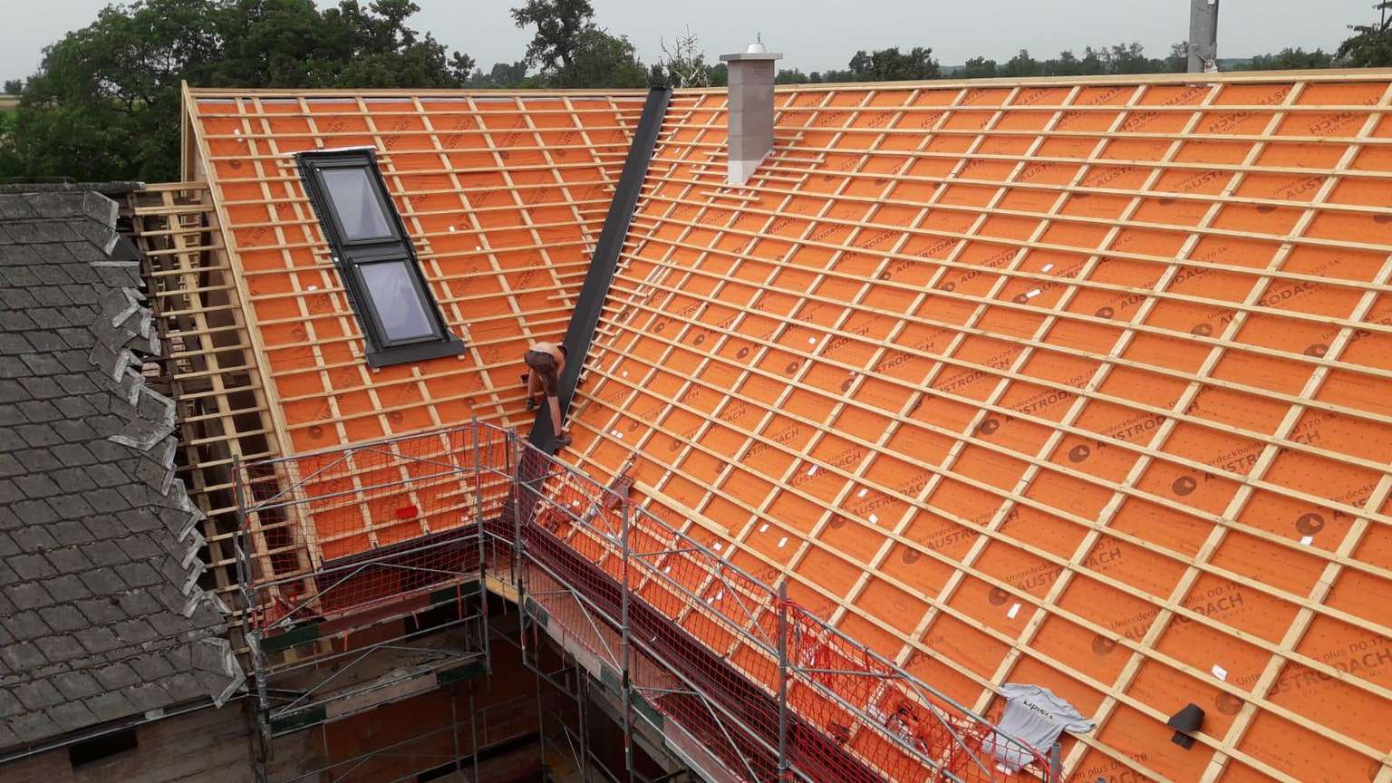 Dachansicht von oben mit Holzstreben im Bauprozess und Dachfenstern.