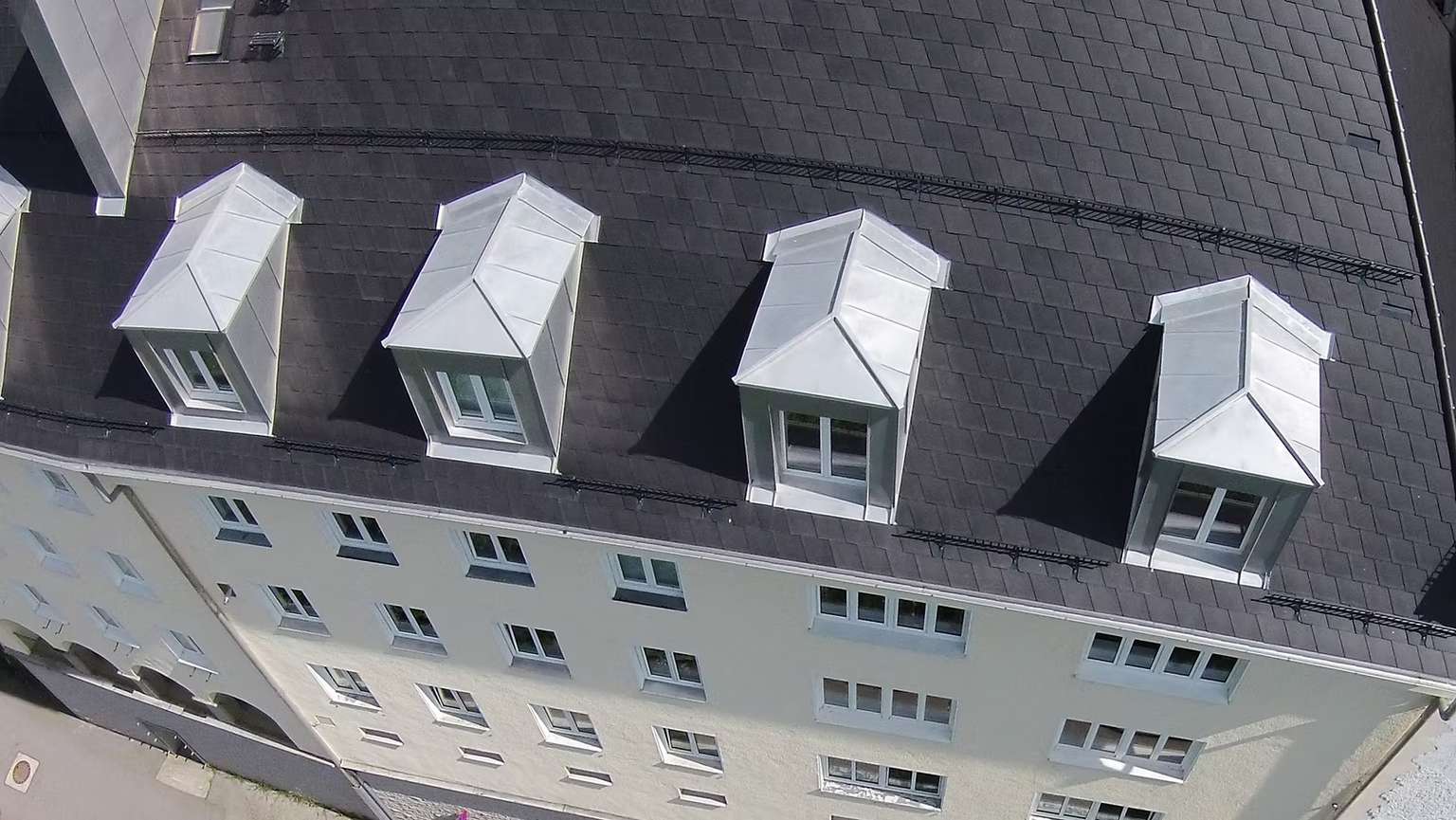 Luftansicht von Wohnkomplexen mit beigener Fassade und grauem Dach.