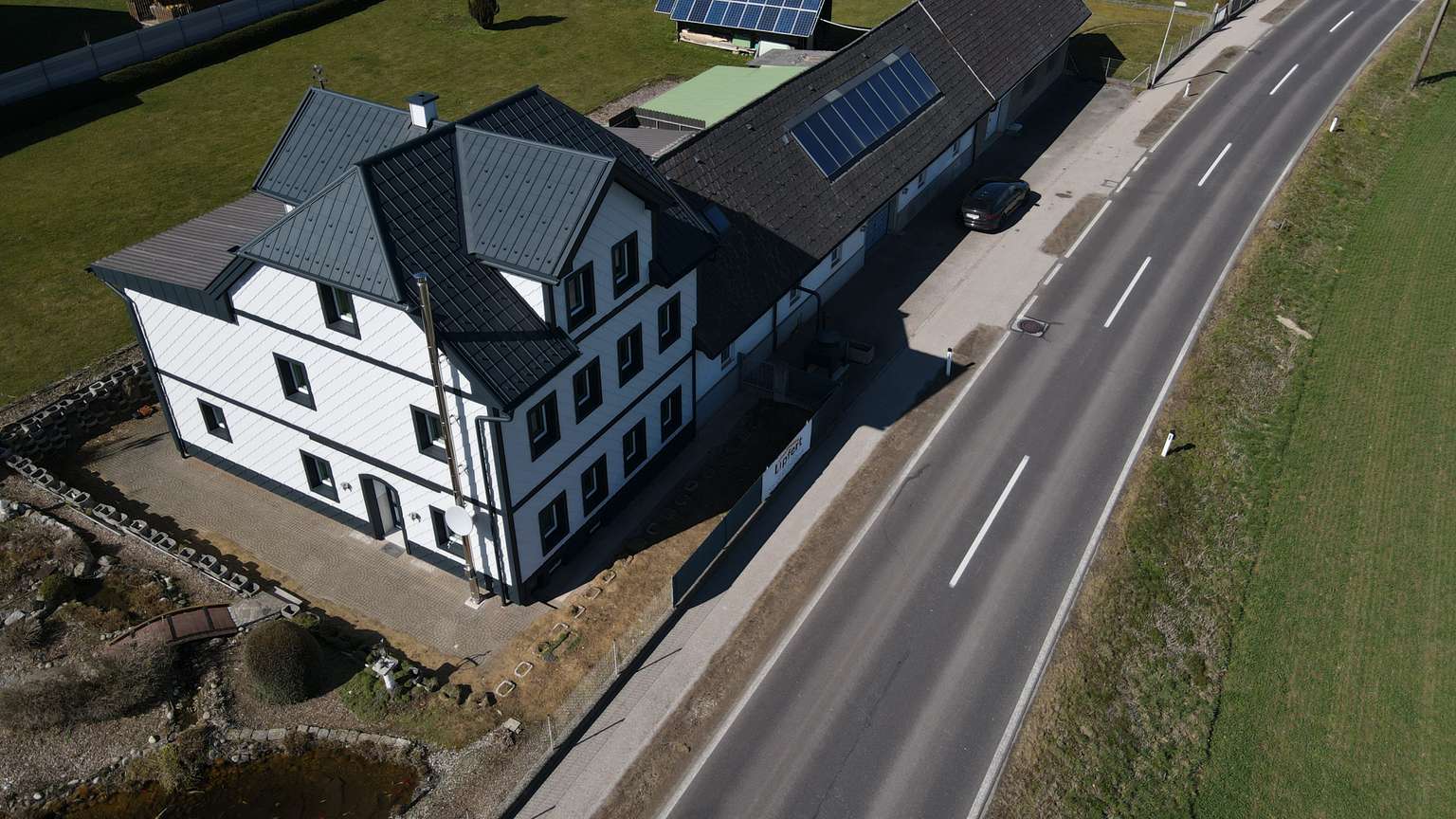 Drohnenaufnahme  mit Ansicht auf das Dach und die Fassade eines Gebäudes.