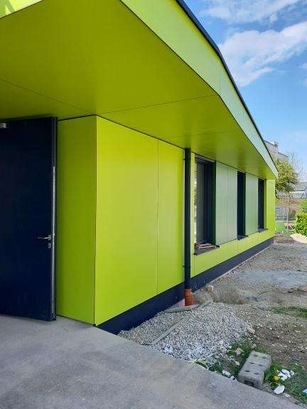 Grüne Fassade eines Hauses mit Vorbau.