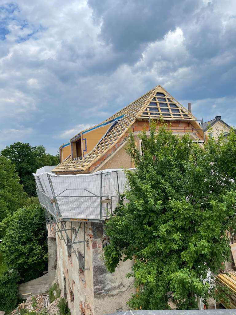Flößerhaus von außen mit Dachgerüst aus Holzbalken und Baugerüst unter dem Dach.