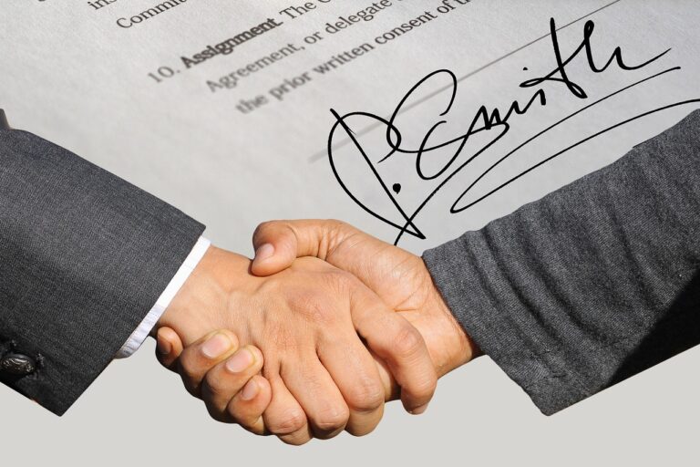 Two people shaking hands over a document with a bold signature, symbolizing agreement or partnership.
