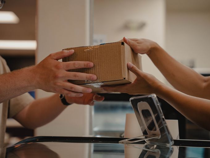 Customer handing off a package to an Avenue Bakery employee