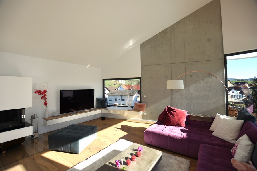 Wohnhaus H-S in Rimbach — Wohnzimmer mit Sichtbetonwand und Fernblick