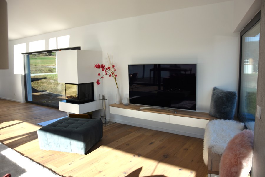 Wohnhaus H-S in Rimbach — Wohnzimmer mit Kamin und bodentiefen Fenstern
