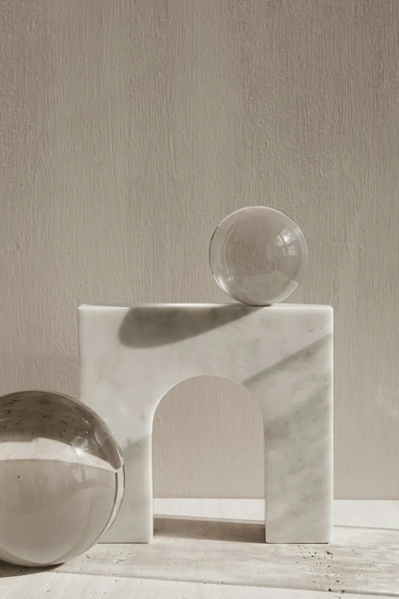 Marble archway and glass spheres in soft natural light