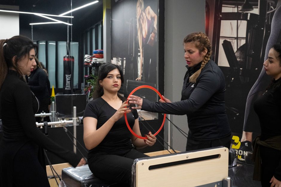 wellness studio staff training a client, the kind of multi-location operations a wellness management solution coordinates