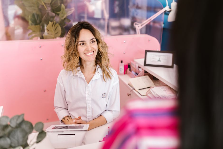 Receptionist welcoming a client at a wellness center front desk