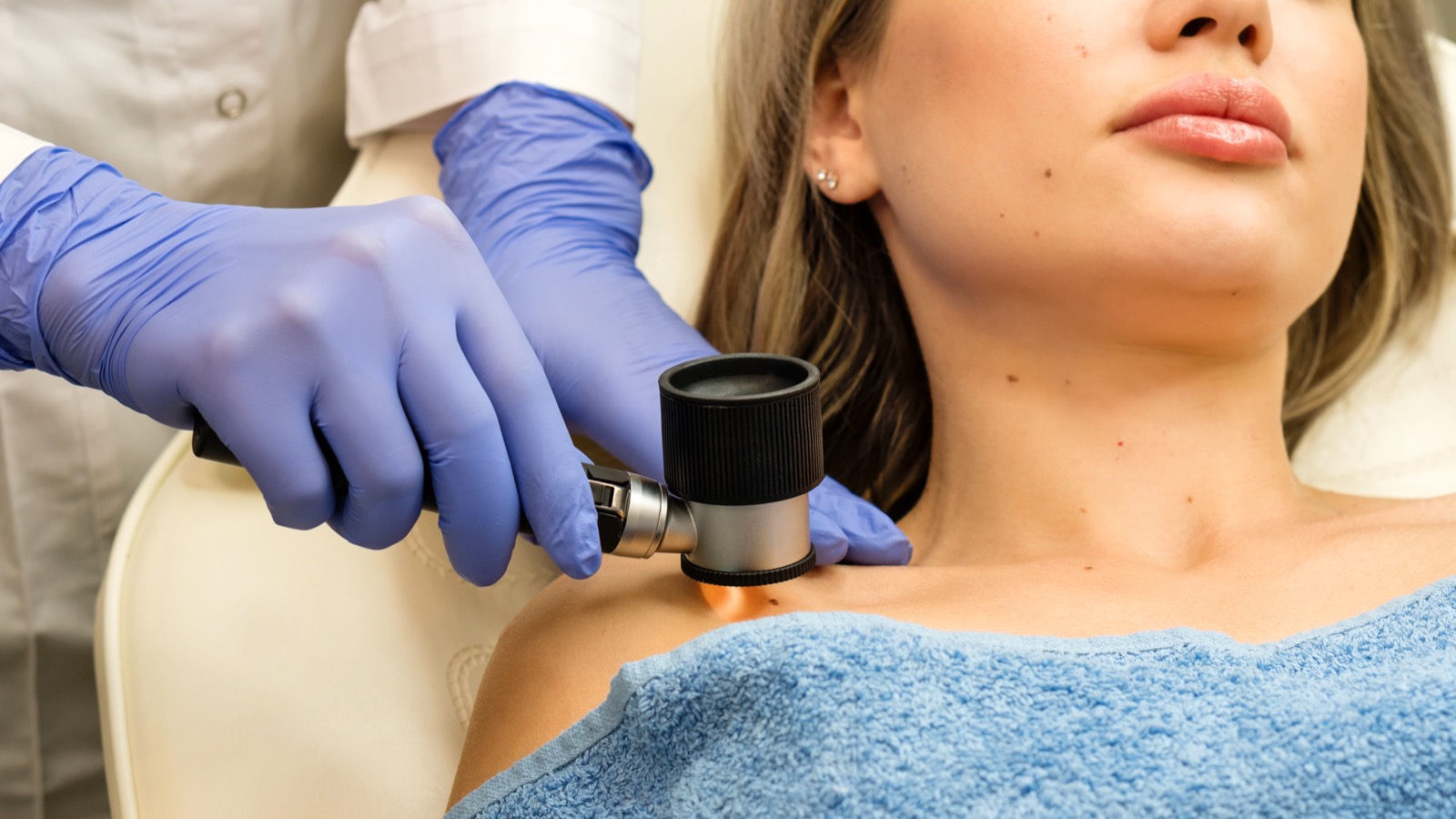 Dermatologist examining skin with a dermatoscope