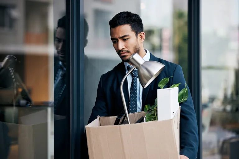 employee leaving workplace with belongings box