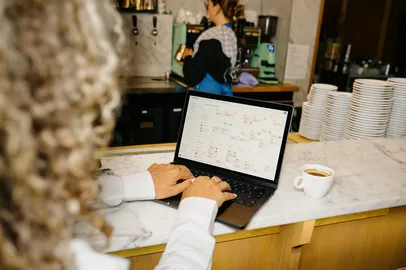 Manager working on the Shiftbase schedule on a laptop at the bar