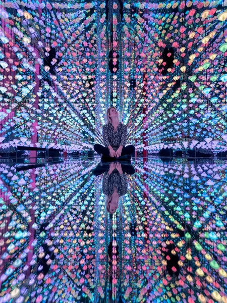 Visitor inside the mirrored light installation at Moco Museum