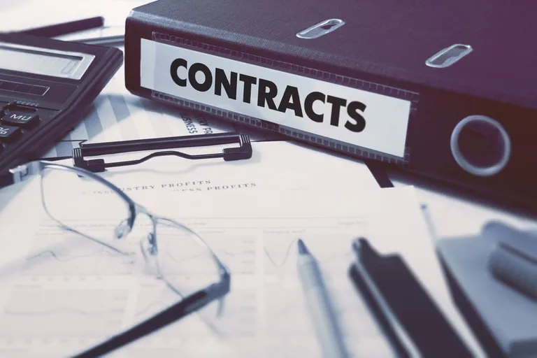 Detailansicht eines Arbeitsvertrags mit angehefteter Zusatzvereinbarung, hervorgehoben durch einen gelben Markierstift