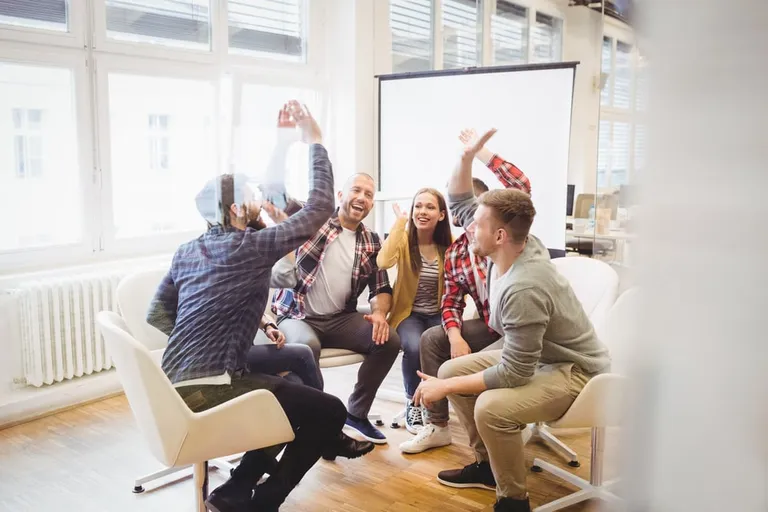Team celebrating with a high-five in a meeting room
