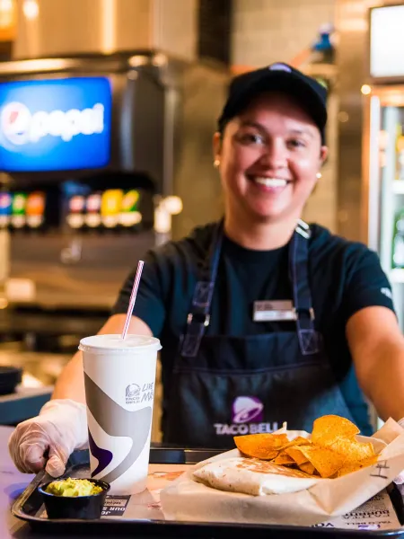 Taco Bell crew member serving an order in Breda