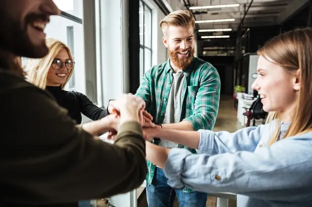 Employés souriants se tenant par les mains au bureau