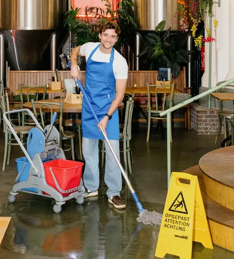 Cleaner mopping the floor of a café before opening