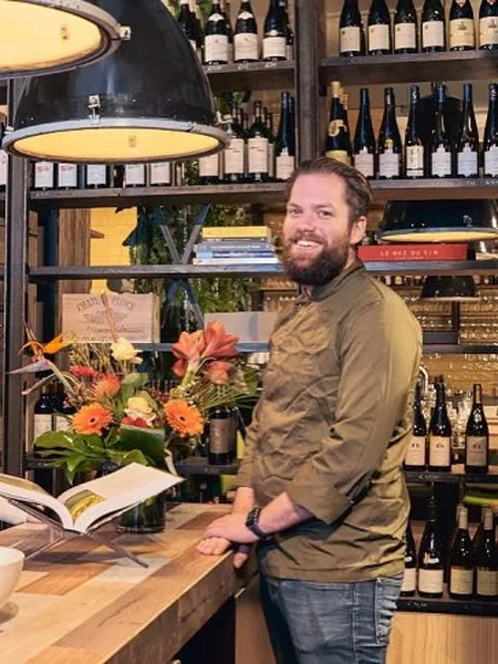 Owner behind the bar at Aards wine bar and shop