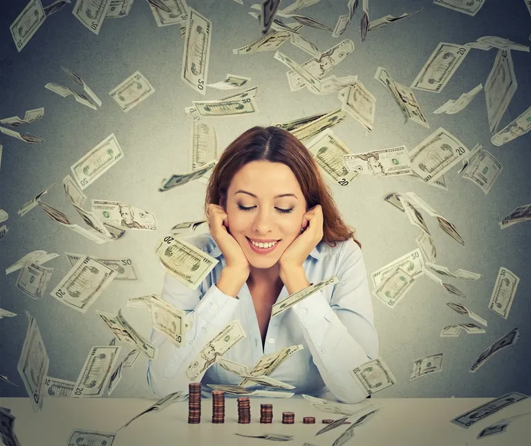 Young woman celebrating financial success with coins