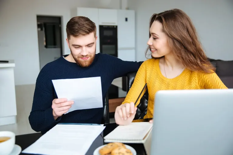 couple calculant des factures à la maison