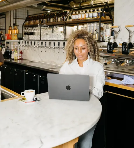 Bar manager working on a laptop at the bar
