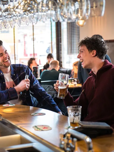 Guests laughing at the bar of News Café