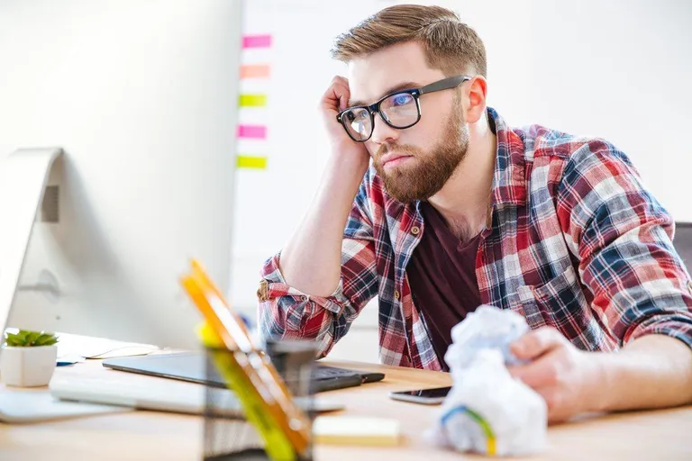 Un empleado mostrando signos de insatisfacción en su espacio de trabajo.