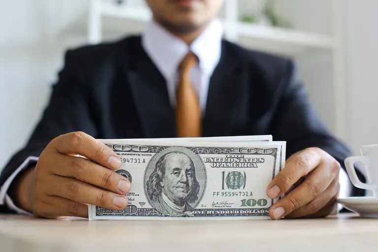 Employee holding money symbolising net pay