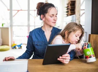 Madre trabajando en casa con su hija a su lado