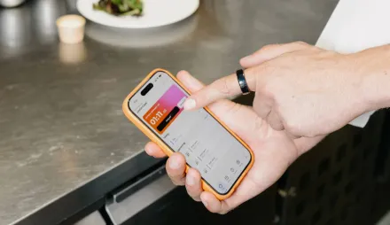 Einstempeln mit der Shiftbase-App auf dem Smartphone an der Küchentheke