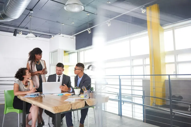 Team discussing job rotation during a meeting in a sunlit office