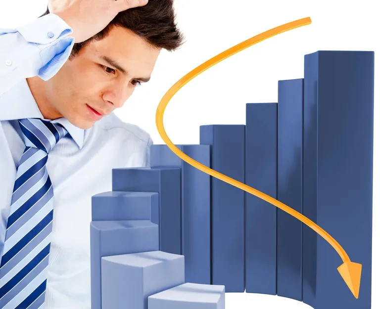 Worried business man with a graph decreasing