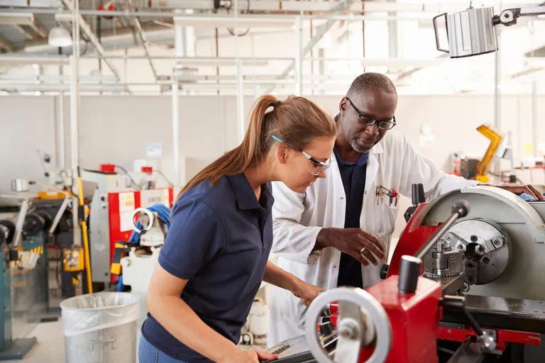 engineer showing new employee how the machine works