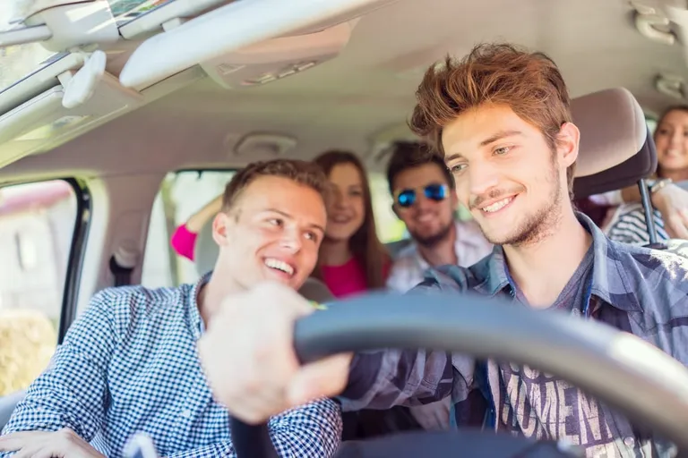Jóvenes disfrutando de vacaciones conduciendo un coche