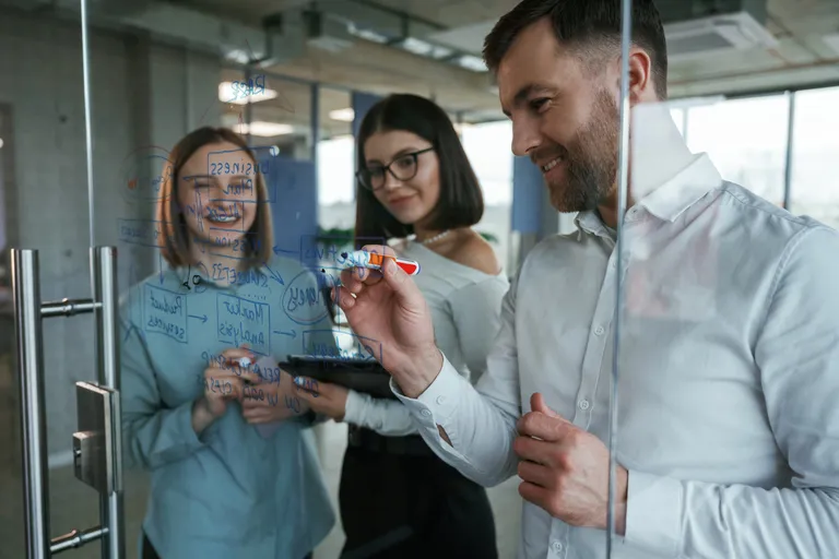 office worker working together on whiteboard project
