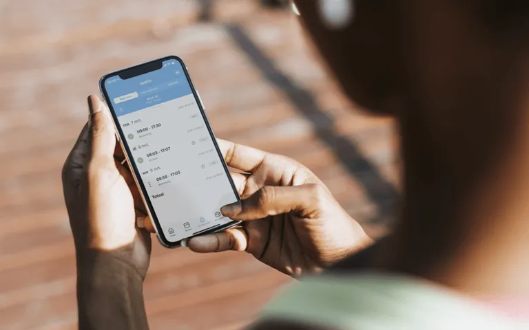 Utilisateur consultant son planning sur téléphone avec Shiftbase