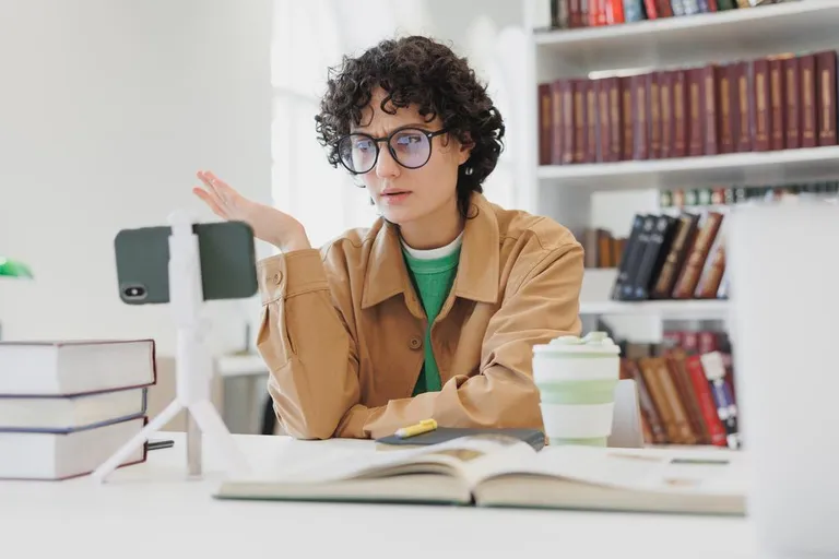 Woman working remotely with mobile phone in home office